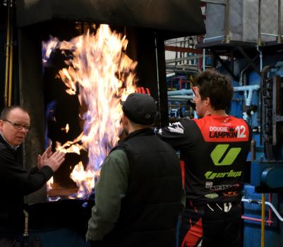 6) Dougie Lampkin warming up by the heat of a furnace before the hard work begins